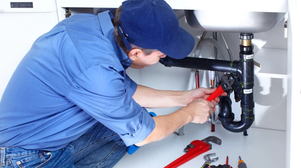 Technician using specialized equipment to ensure proper plumbing system performance in a residential environment, demonstrating expertise in plumbing repairs and maintenance.