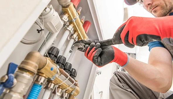 Team member working on commercial plumbing fixtures in Deerfield Beach, FL, highlighting professional services for maintaining efficient water systems in businesses.