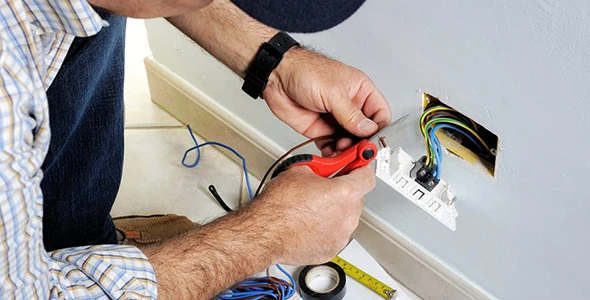 Technician working on a wiring issue in a residential setting in Miami, FL, showcasing reliable electrical services for homeowners.